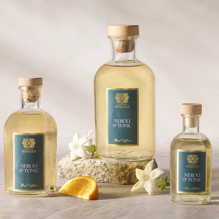 Three bottles of Absinth on a light wooden surface with a neutral background