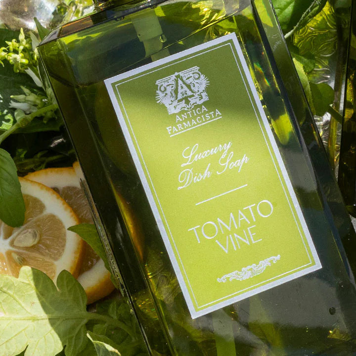 Two bottles of Tomato Vine wine with lemon slices and green leaves on a wooden surface.